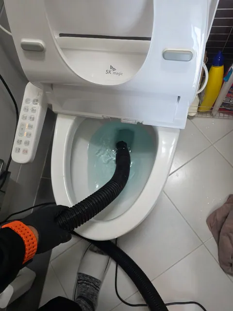변기 안에 흡입 호스를 넣어 작업하는 모습